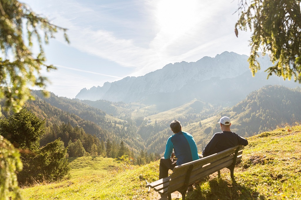 Zwei Wanderer genießen die Aussicht aufs Kaisergebirge